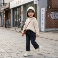 ترکیب شلوار جین بگ دخترانه آبی تیره با پلیور بافتنی در استایل پاییزی.