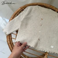 ژاکت دخترانه جلو دکمه ترند روی صندلی حصیری