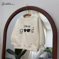 نمای نزدیک گلدوزی Life is good روی بلوز دخترانه کرم روشن